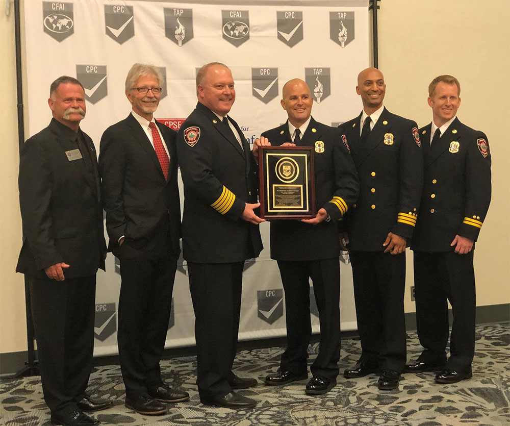 Fire department officials receiving an award during a formal ceremony